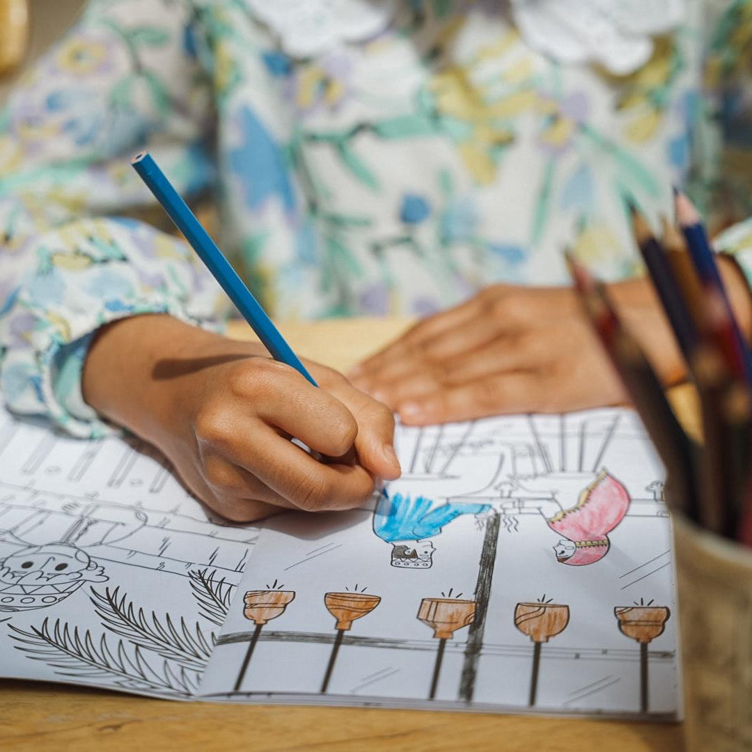 Child coloring a picture with crayons on a table